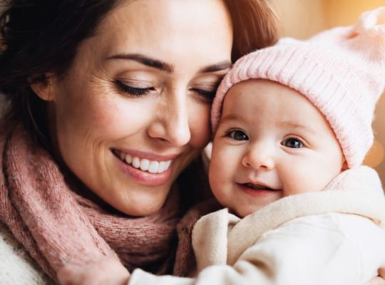 A mother and her infant sharing a loving gaze and smile, exemplifying the formation of a secure emotional connection.