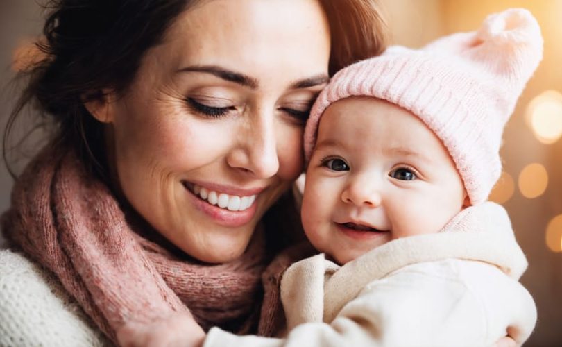 A mother and her infant sharing a loving gaze and smile, exemplifying the formation of a secure emotional connection.