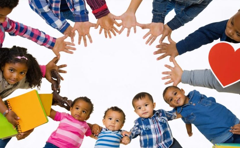Diverse group of children from different cultural backgrounds holding hands in a circle, symbolizing unity and support in addressing mental health care disparities.