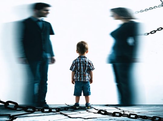 Child standing between two blurred parent figures, illustrating the emotional distress and conflict of parental alienation.