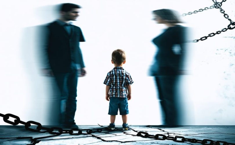 Child standing between two blurred parent figures, illustrating the emotional distress and conflict of parental alienation.