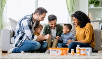 "Family members sitting together in a living room, sharing a warm and supportive moment, with elements suggesting medical challenges subtly present in the background."