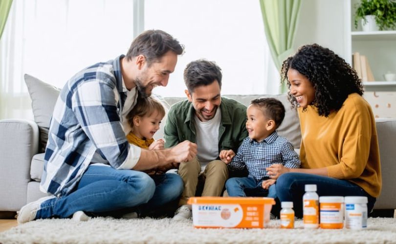 "Family members sitting together in a living room, sharing a warm and supportive moment, with elements suggesting medical challenges subtly present in the background."