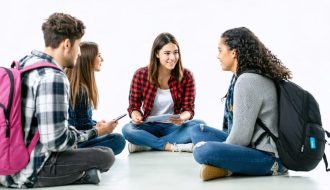 A diverse group of students and a school counselor in a supportive therapy session within a welcoming school environment, representing the importance of accessible mental health services.