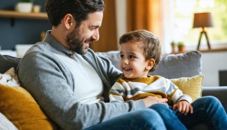 Parent and child sitting on a cozy living room couch, engaged in a supportive conversation about emotions, symbolizing mental health literacy and emotional well-being.