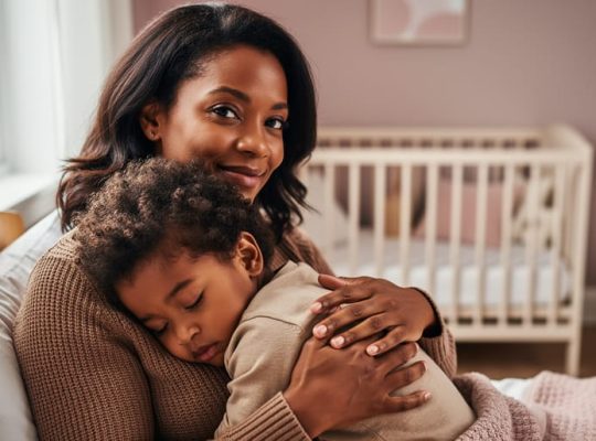 Parent holding a child close during a soothing moment, conveying emotional security and nurturing attachment.